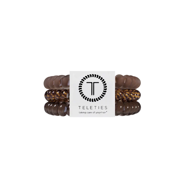 Three Teleties stretch bracelets in dark brown, medium brown, and leopard print, wrapped together with a white paper band featuring the Teleties logo.