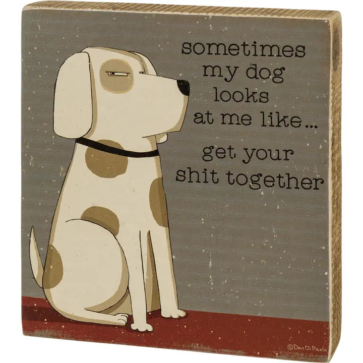 Wooden sign with a dog illustration and humorous text on a gray background