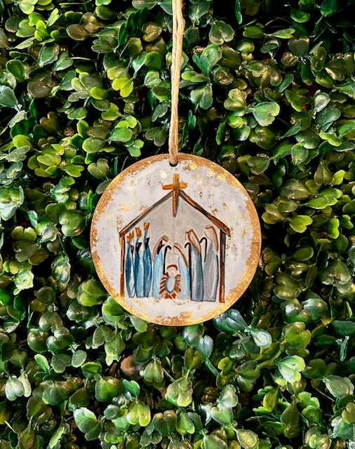 Decorative ornament with nativity scene design on a green leafy background