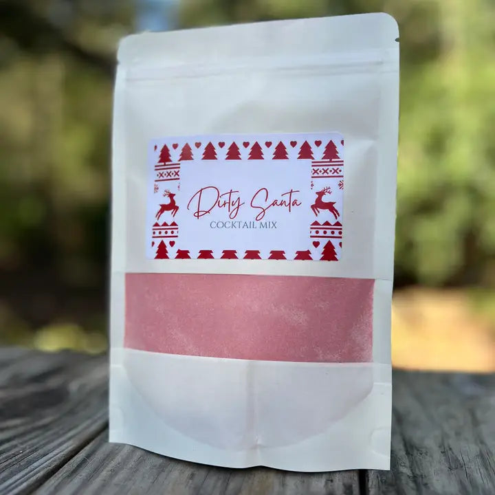 White packaging of 'Dirty Santa Cocktail Mix' with red text and patterns on a wooden surface.