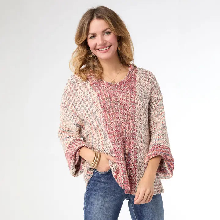 Woman wearing a patterned sweater and jeans on a white background