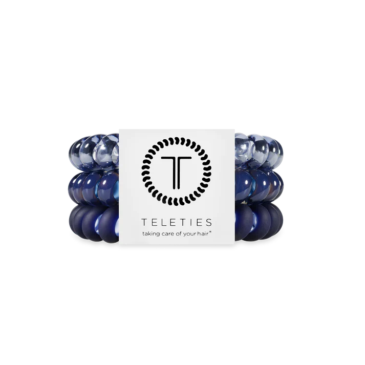 Set of blue hair ties with a Teleties branded card on a white background