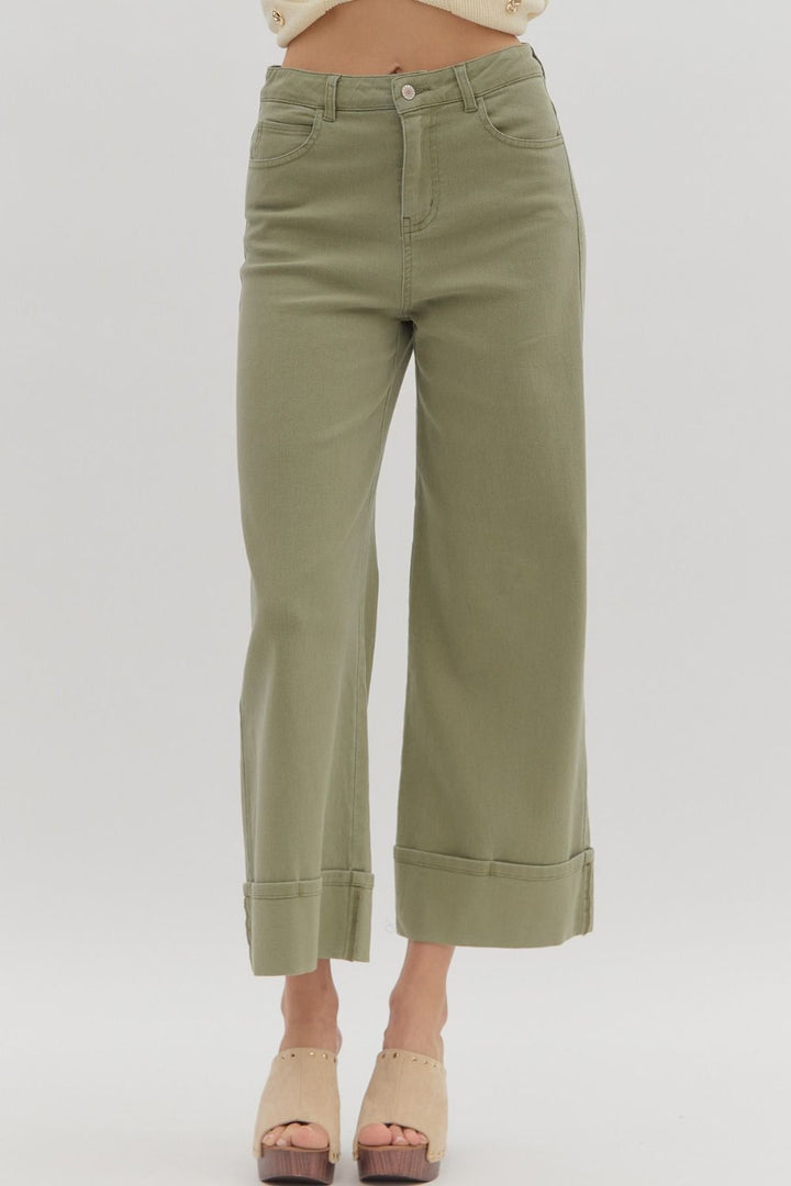 Green pants worn by a person on a white background