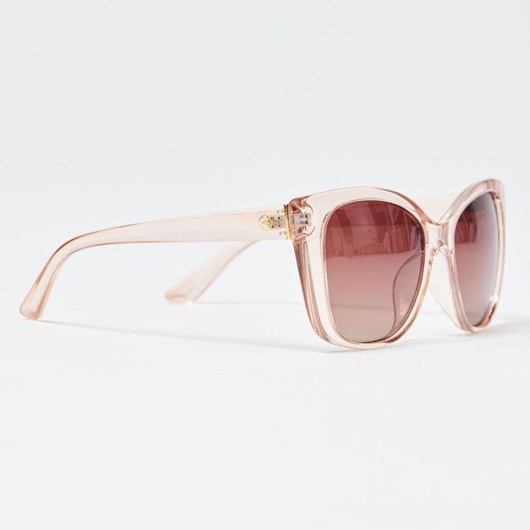 Sunglasses with pink frame and brown lenses on a light gray background