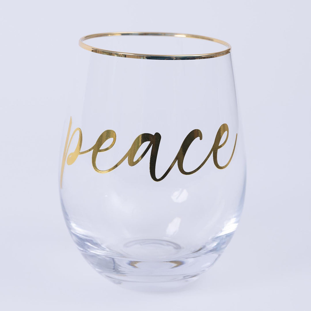 Clear glass with gold rim and 'peace' text on a light gray background