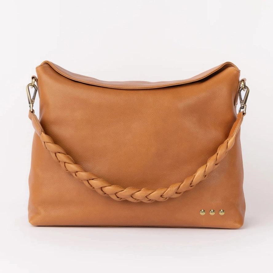 Brown leather handbag with braided handle on a white background