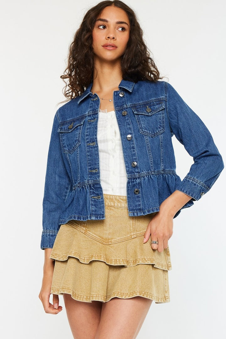 Woman wearing a blue denim jacket and beige skirt on a white background