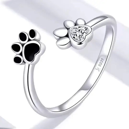 Silver ring with paw print designs on a white background