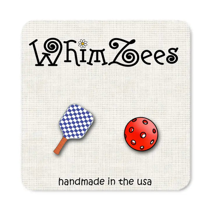Two pins, one resembling a paddle and the other a ball, on a card with 'WhimZees' branding.