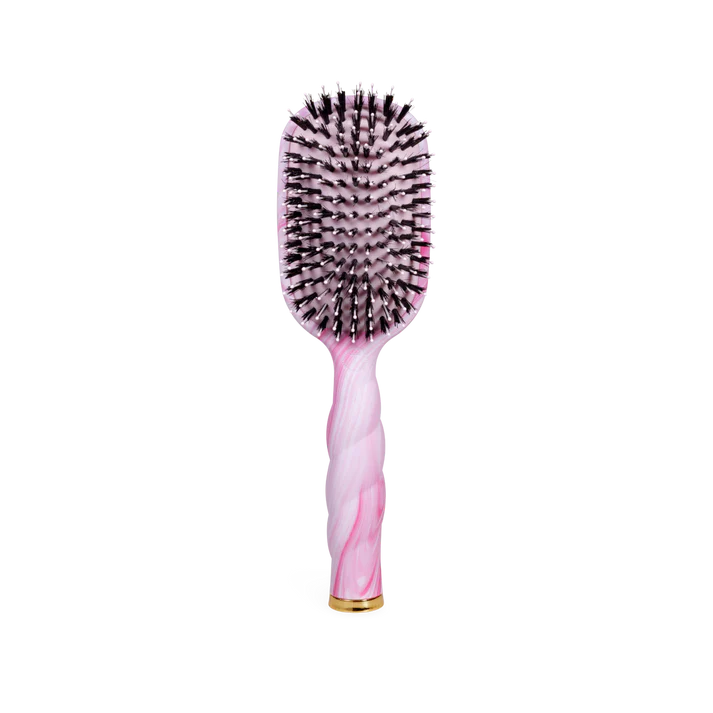 Hairbrush with pink handle and black bristles on a white background