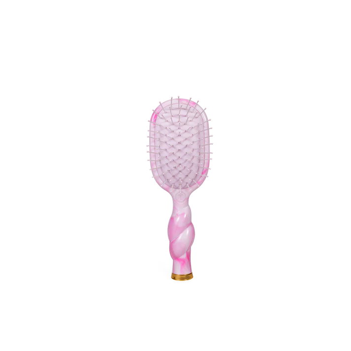 Pink and gold hairbrush on a white background