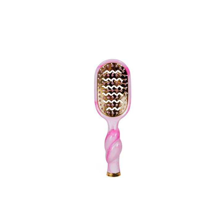 Pink and gold hairbrush on a white background