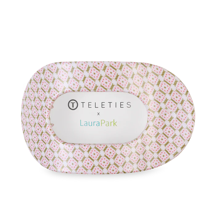 Pink and gold patterned product with 'Teleties' and 'Laura Park' branding on a white background