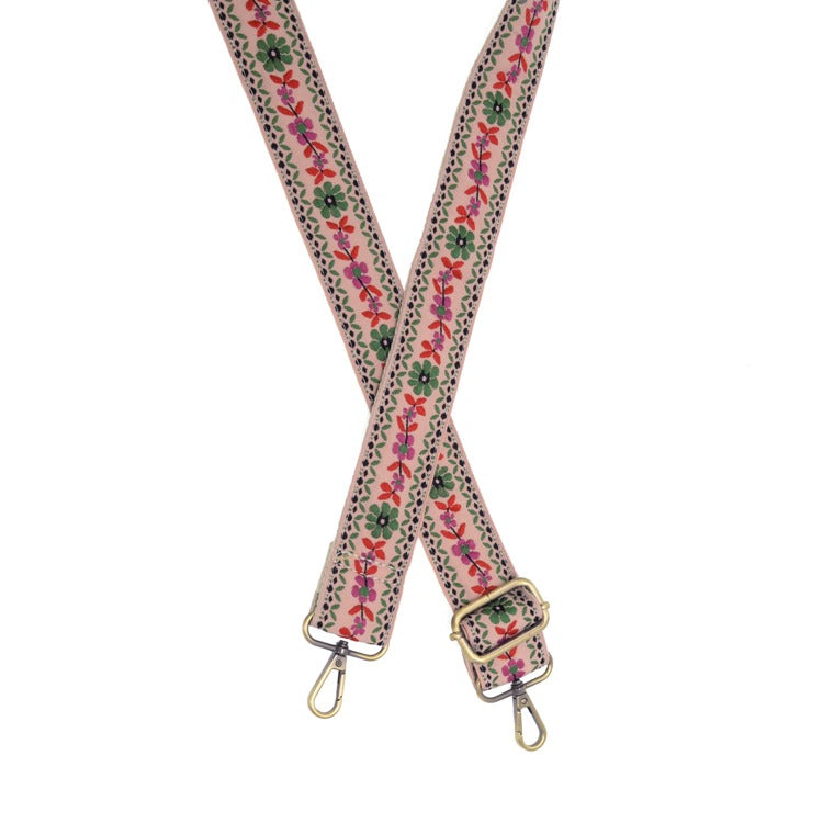 Floral patterned strap with gold hardware on a white background