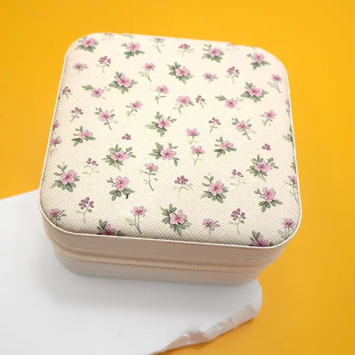 Floral-patterned jewelry box on a white surface with a yellow background