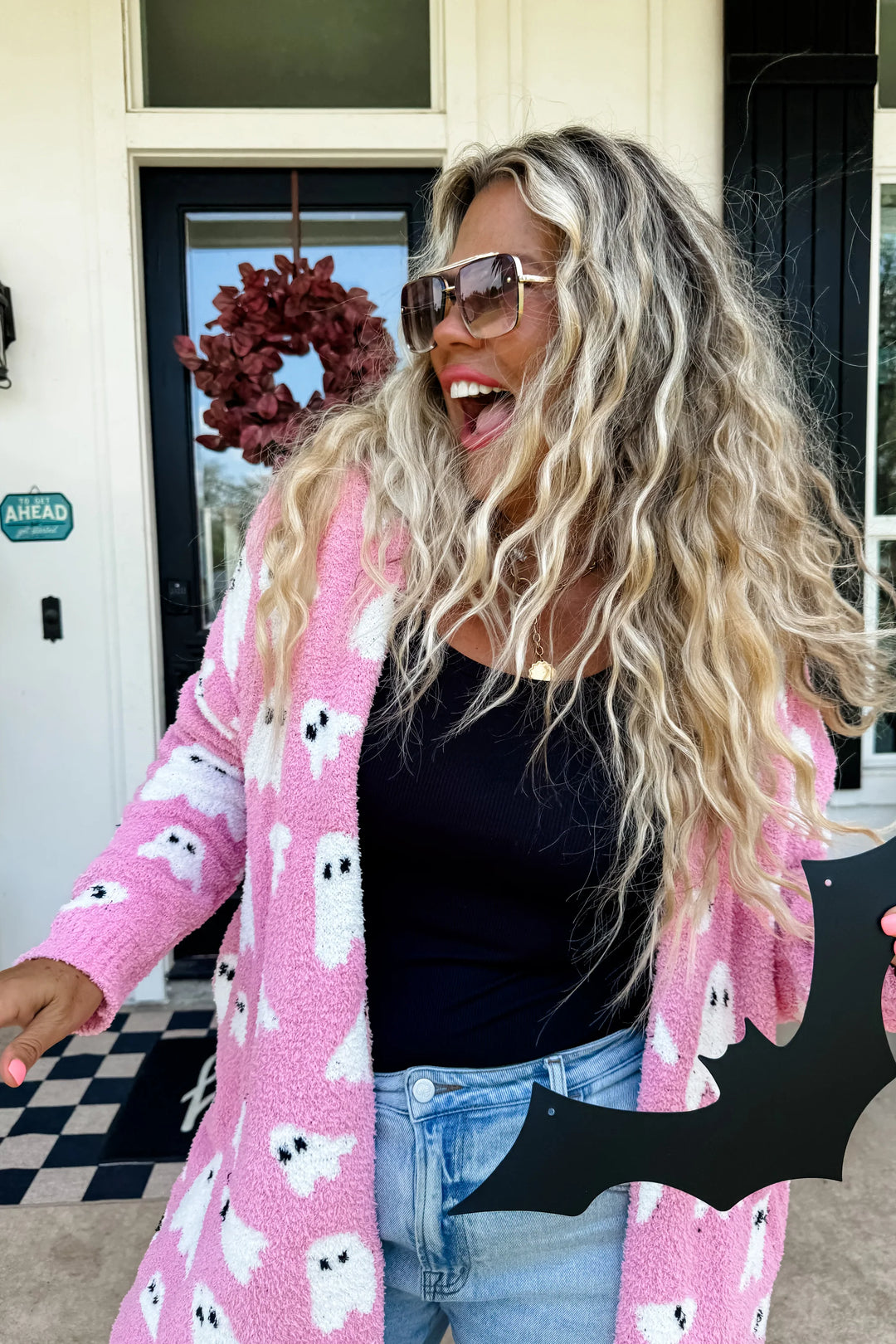woman wearing long pink cardigan with white ghosts
