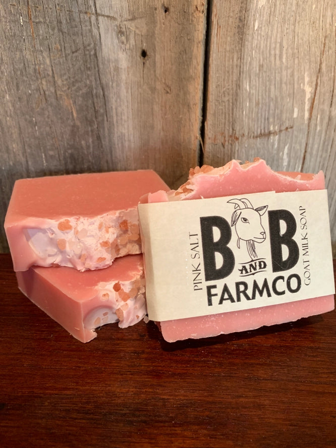 Pink soap bar with a label on a wooden surface