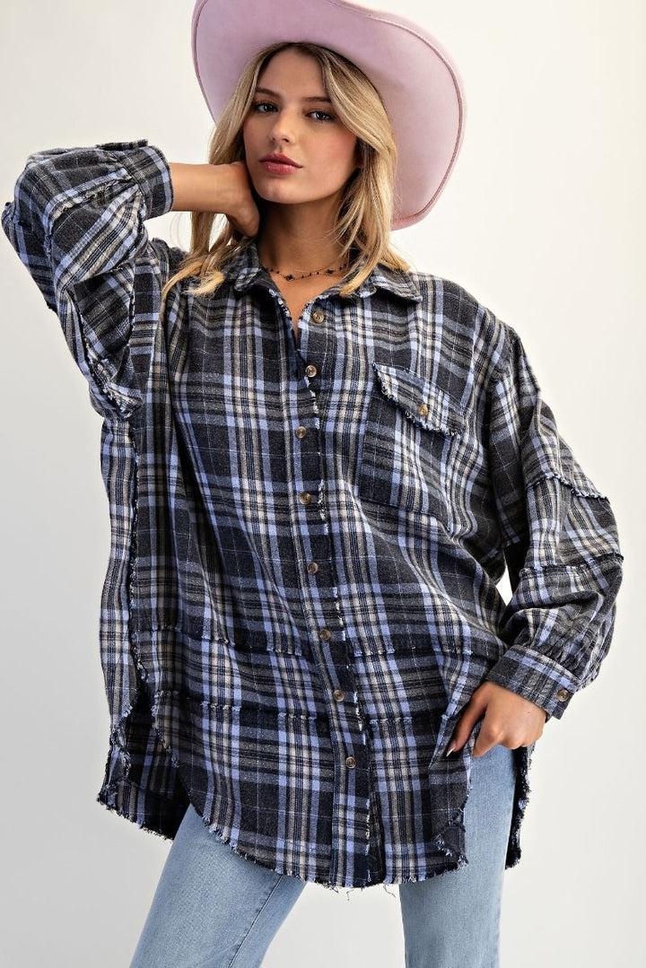Woman wearing a plaid shirt and pink hat against a plain background