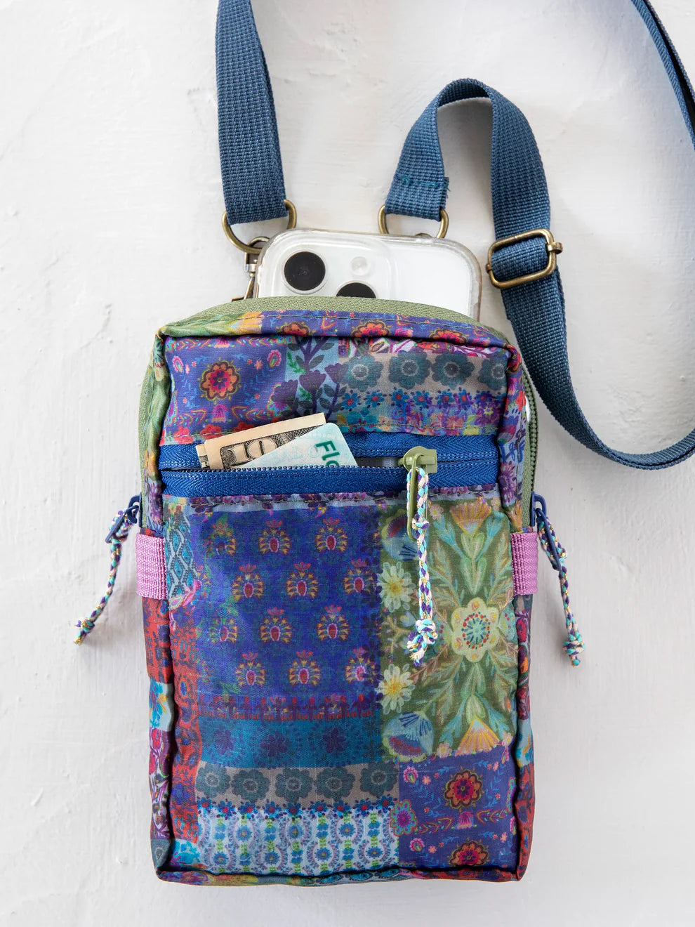 Multicolored patterned crossbody bag with a phone case on a white background
