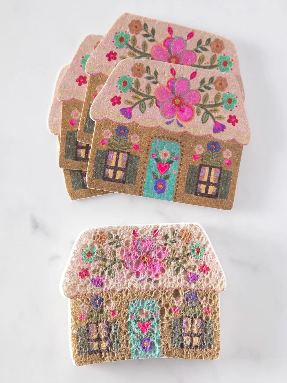 Set of three decorative house-shaped coasters with floral designs on a white background