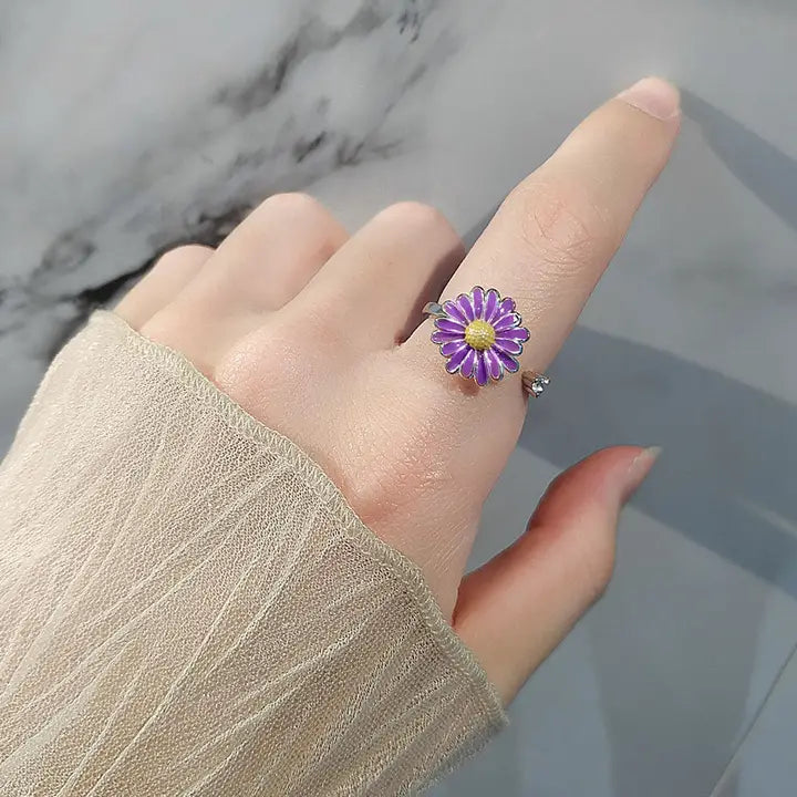 hand with a purple daisy ring