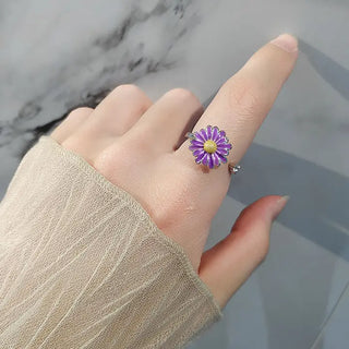 hand with a purple daisy ring