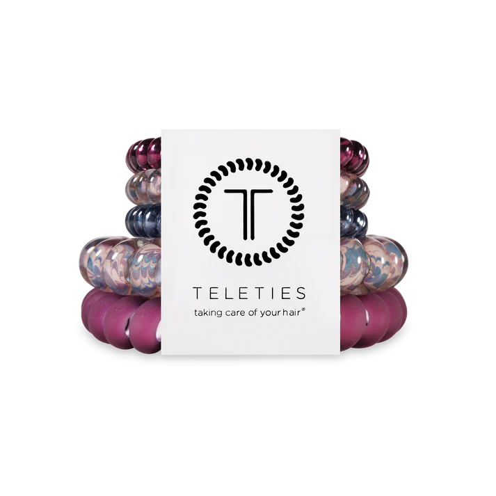Stack of colorful hair ties with a Teleties branded box on a white background