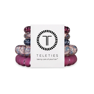 Stack of colorful hair ties with a Teleties branded box on a white background