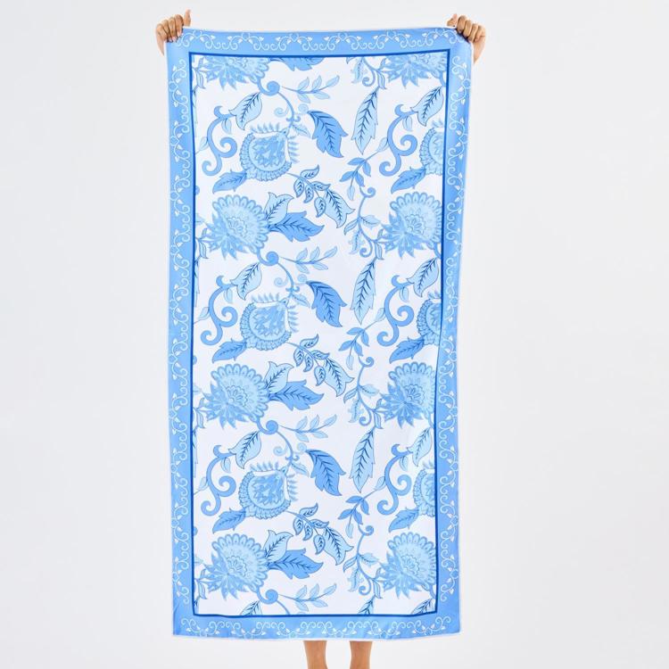 Person holding a blue floral patterned towel against a white background