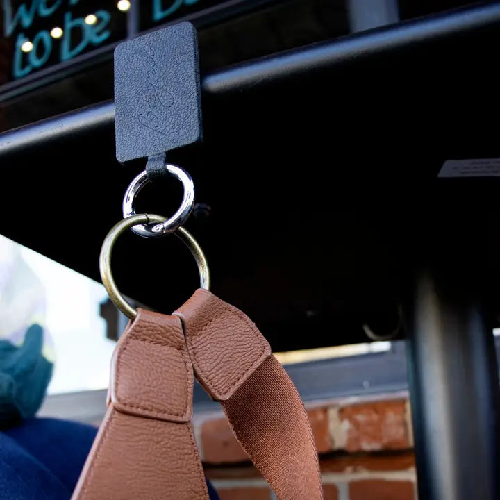 Keychain with brown strap attached to a car&