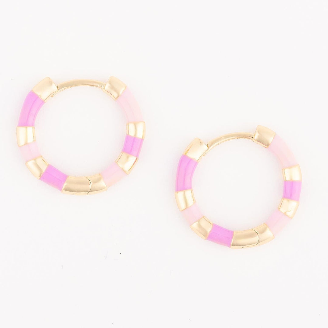 Pair of gold hoop earrings with pink and white accents on a white background