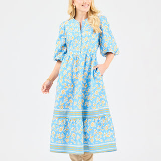 Woman wearing a blue floral dress on a white background