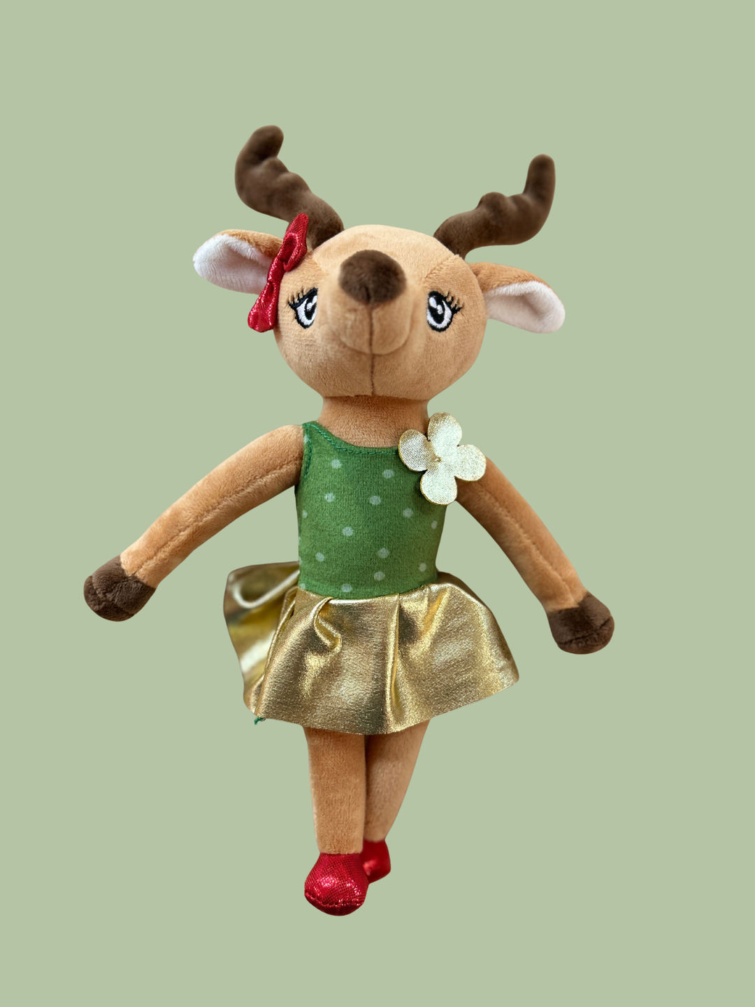 Plush deer toy with a green top and gold skirt on a light green background