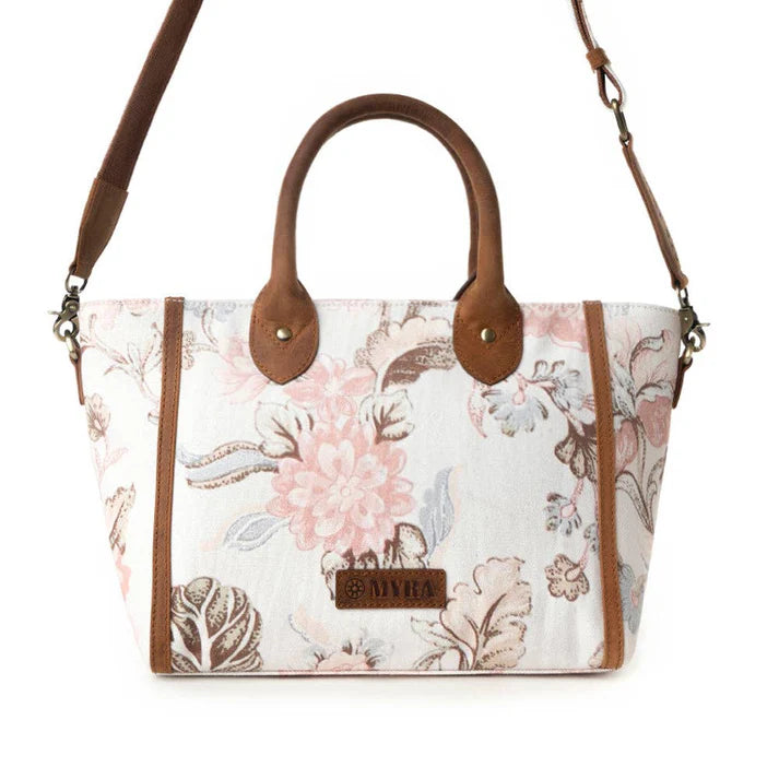 Floral-patterned handbag with brown leather accents on a white background