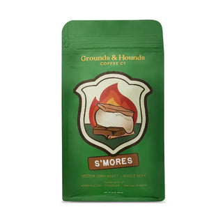 A green stand-up coffee bag labeled Grounds & Hounds Coffee Co. S'mores, with a campfire graphic and flavor text on a white background.