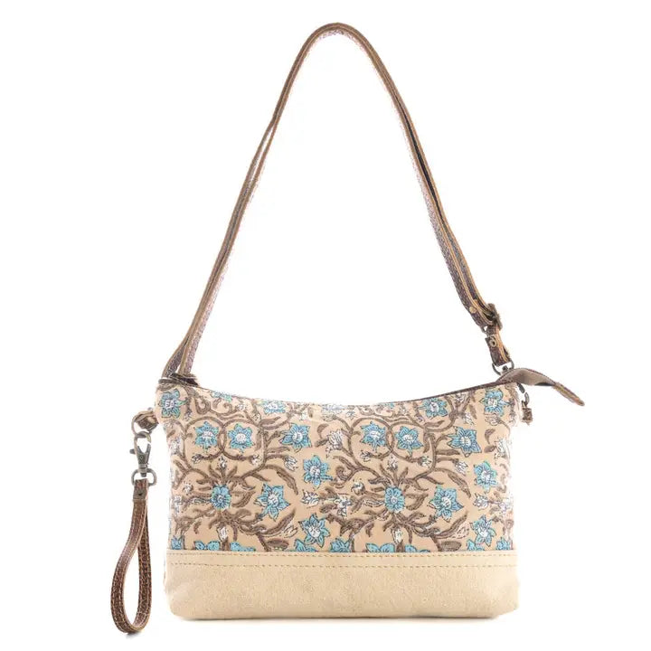 Floral patterned handbag with beige base on a white background