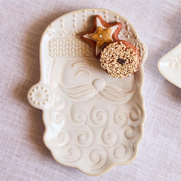 Decorative ceramic cookie cutter shaped like a mermaid with two small cookies on top, on a light fabric background.