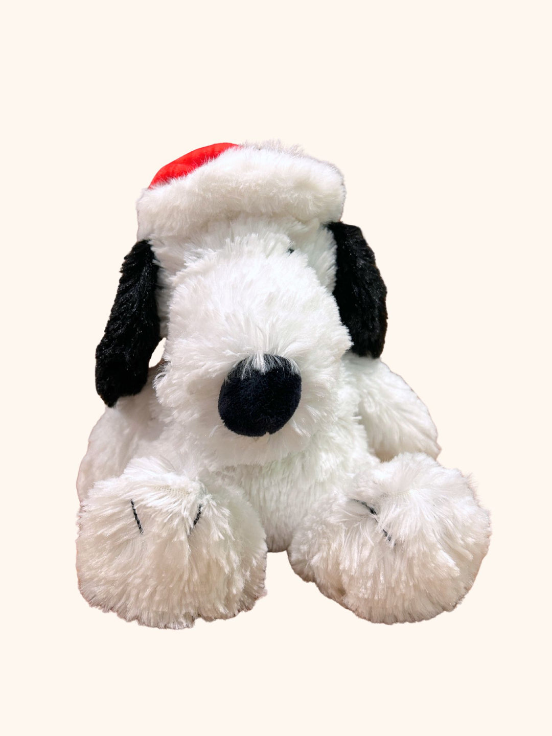 Plush dog toy with a Santa hat on a white background