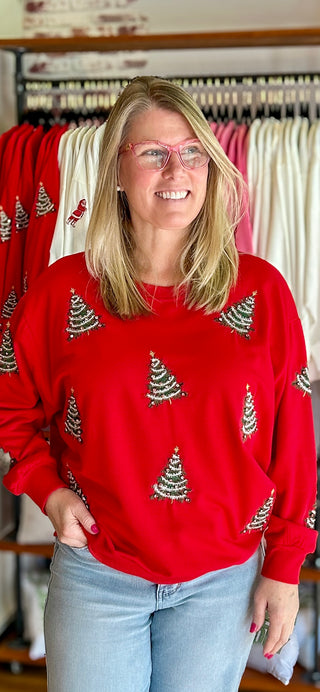 woman in red sweatshirt with green glittery Christmas trees