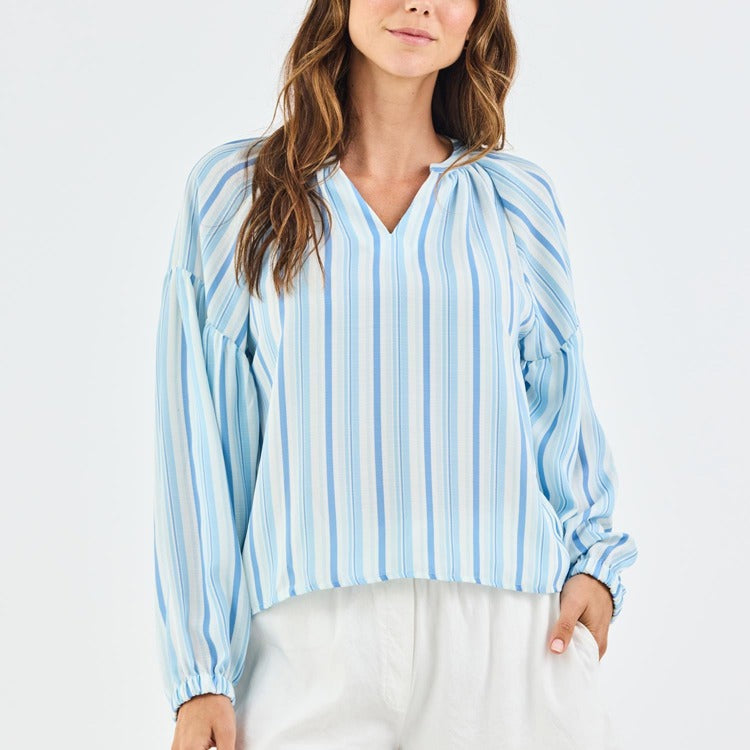 Woman wearing a blue and white striped blouse on a light gray background