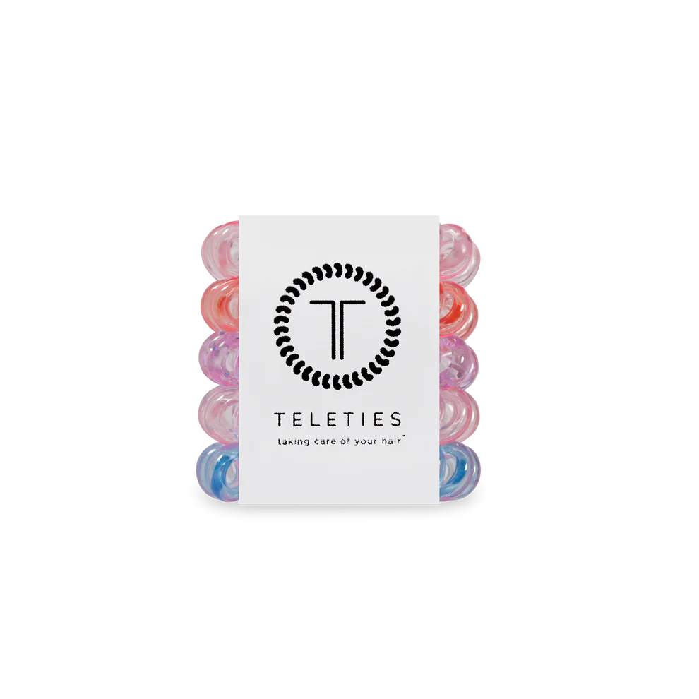 Set of colorful hair rollers with a Teleties branded card on a white background
