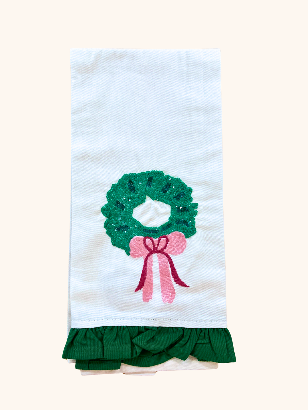Towel with a green wreath and pink bow design on a white background