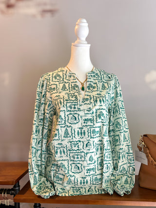 Cream top with green Christmas themed toile like print all over. Santa, trees, nutcrackers, greenery are all part of the designs. Split v neck with elastic at cuffs. 