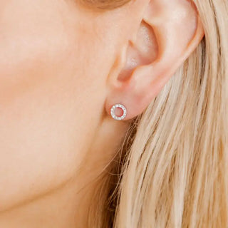 Close-up of an ear wearing a round earring 