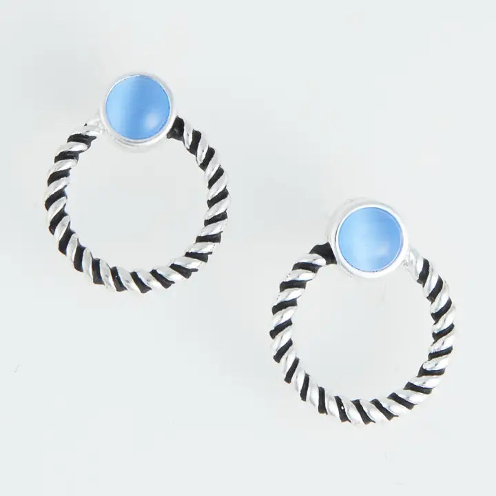 Pair of hoop earrings with black and white striped design and blue circular centers on a light gray background