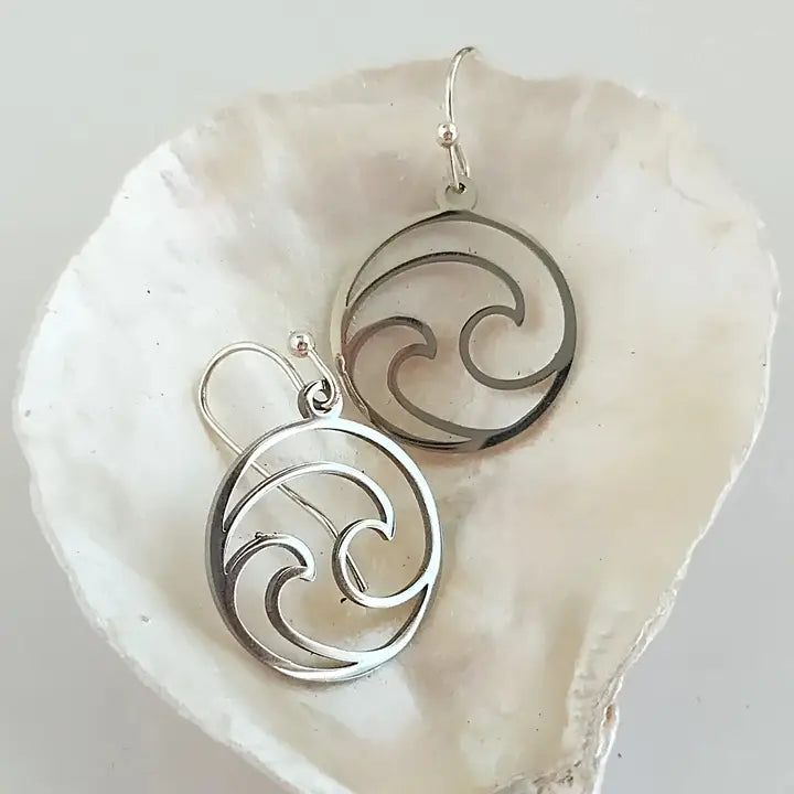 Silver circular earrings on a white shell