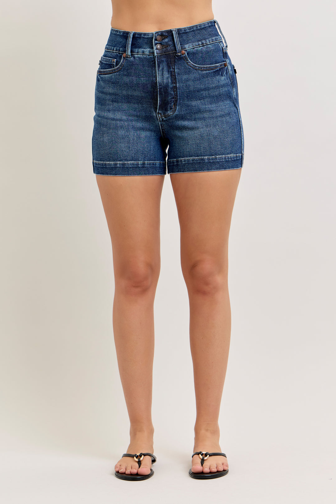 Person wearing blue denim shorts on a plain background