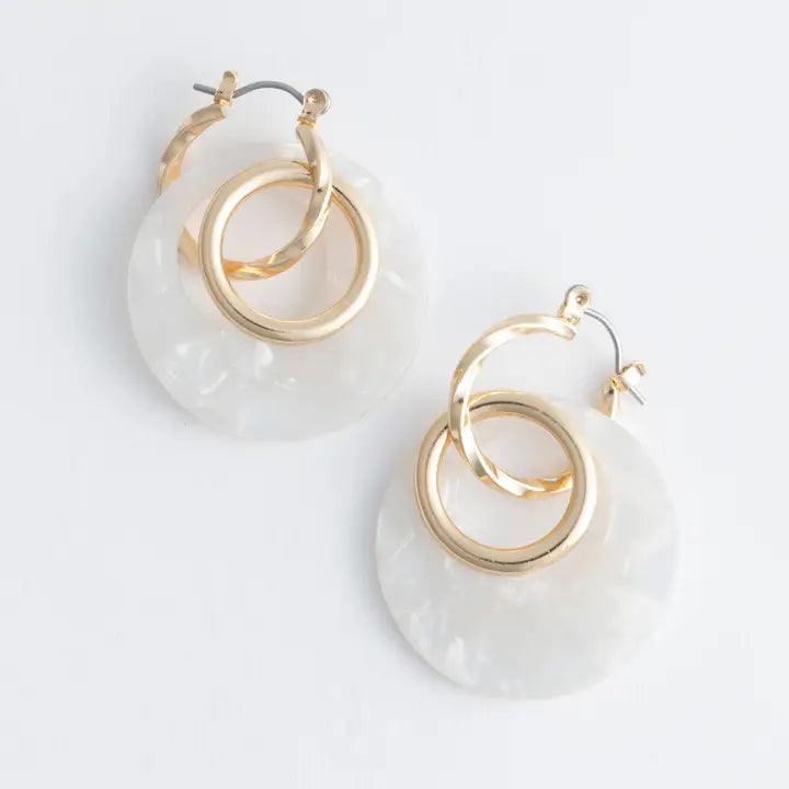 Gold hoop earrings with clear acrylic rings on a white background