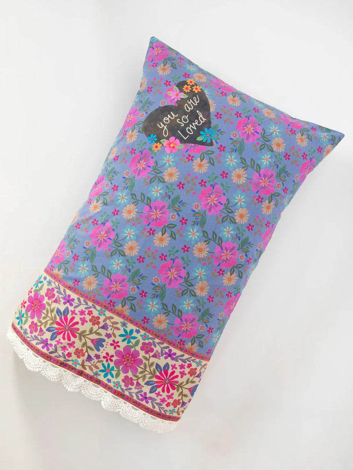 Floral patterned pillow with text on a white background