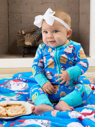 baby wearing blue onesie with mugs of hot cocoa pattern